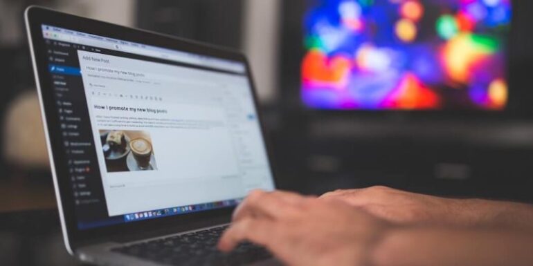 A pair of hands working at a laptop.