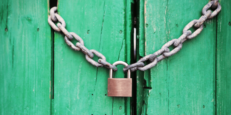 A padlock on a green door.